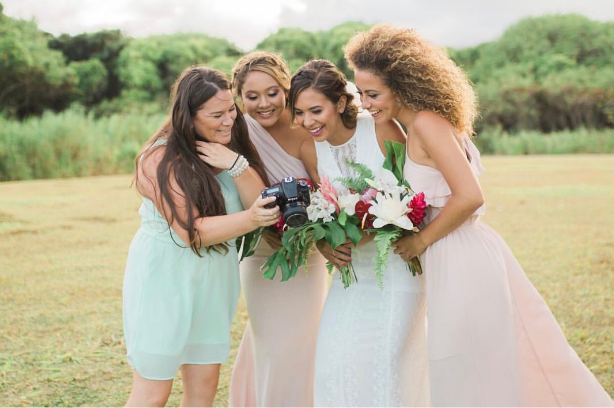 Wedding Photographer showing images to bridesmaids