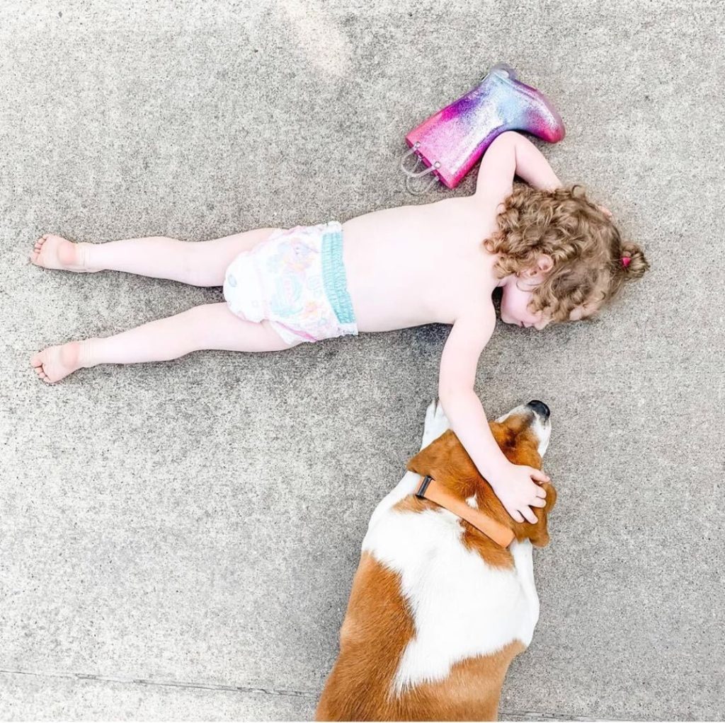 little girl lying down with her dog